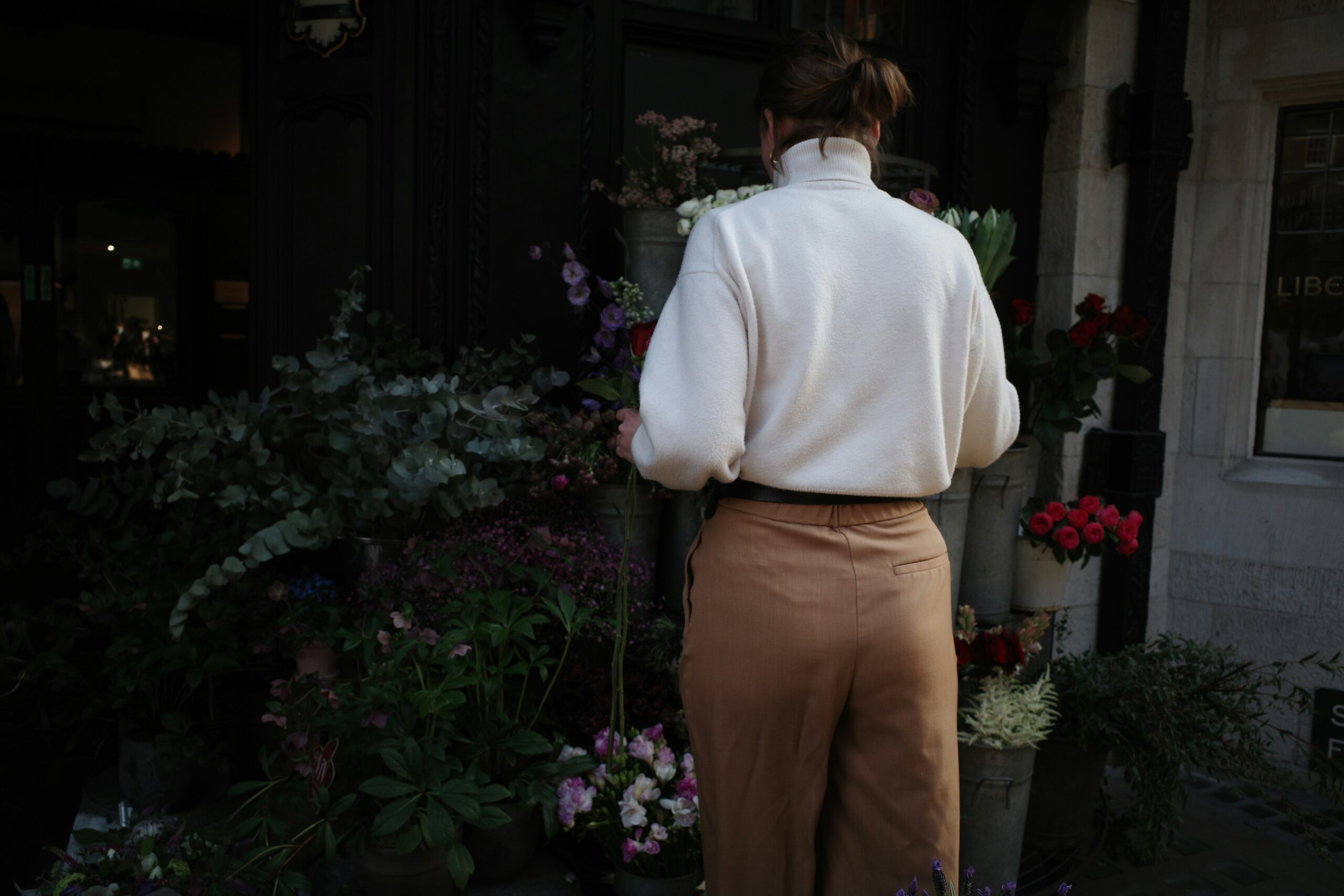 A confident owner walking alongside her perfectly behaved golden retriever in a coffee shop