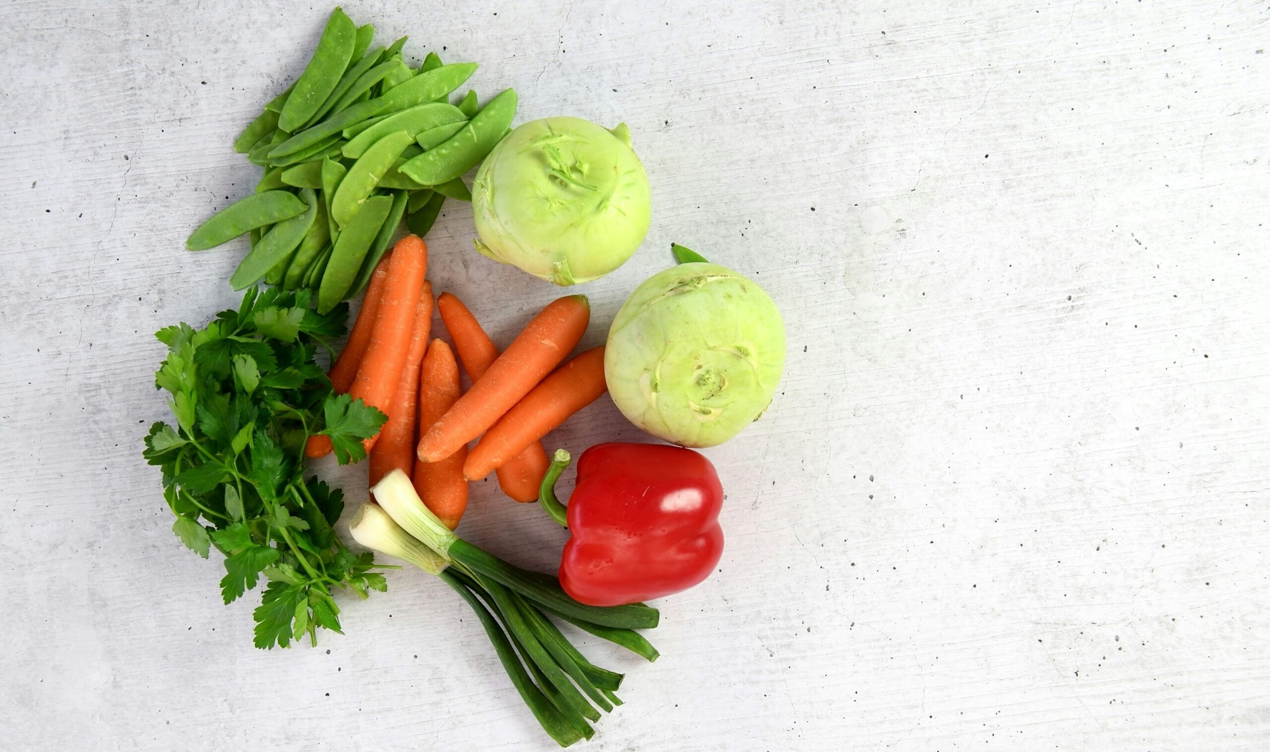 Close-up shot of fresh ingredients including chicken, carrots, and spinach for dog food recipes