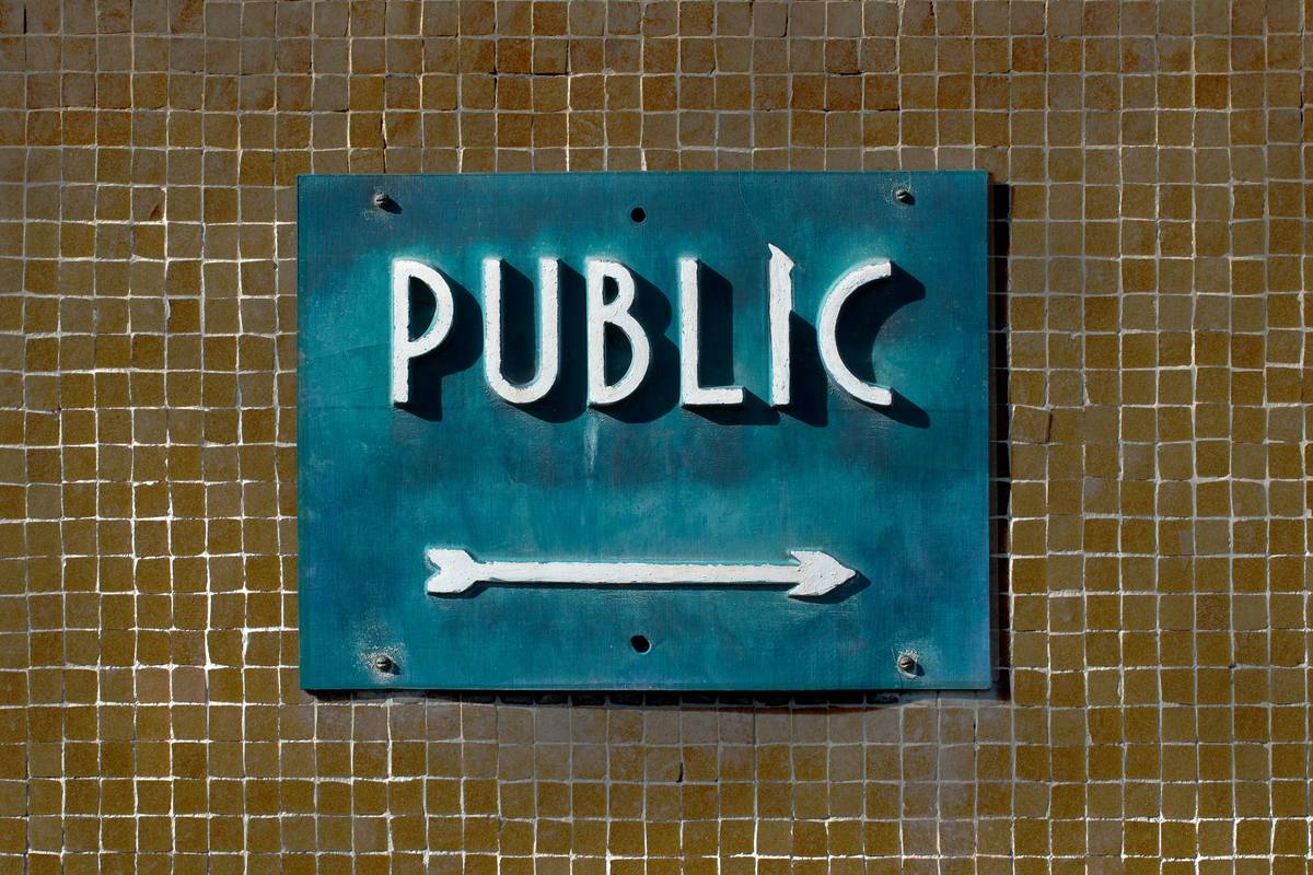 A handler practicing obedience commands with their service dog in a grocery store aisle.